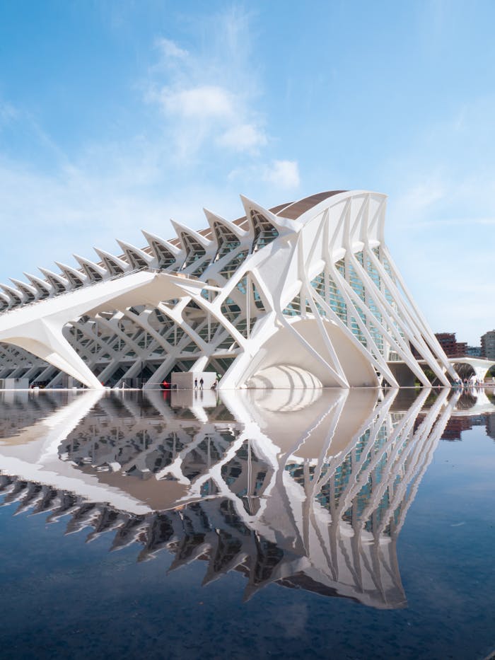 Stunning modern architecture reflecting in water under blue sky in Valencia, Spain.
